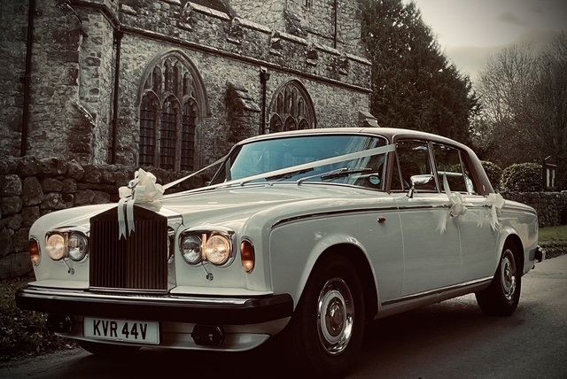 Kingswood Wedding Cars - Rolls-Royce Silver Shadow II decorated with wedding ribbons at church entrance in Kent